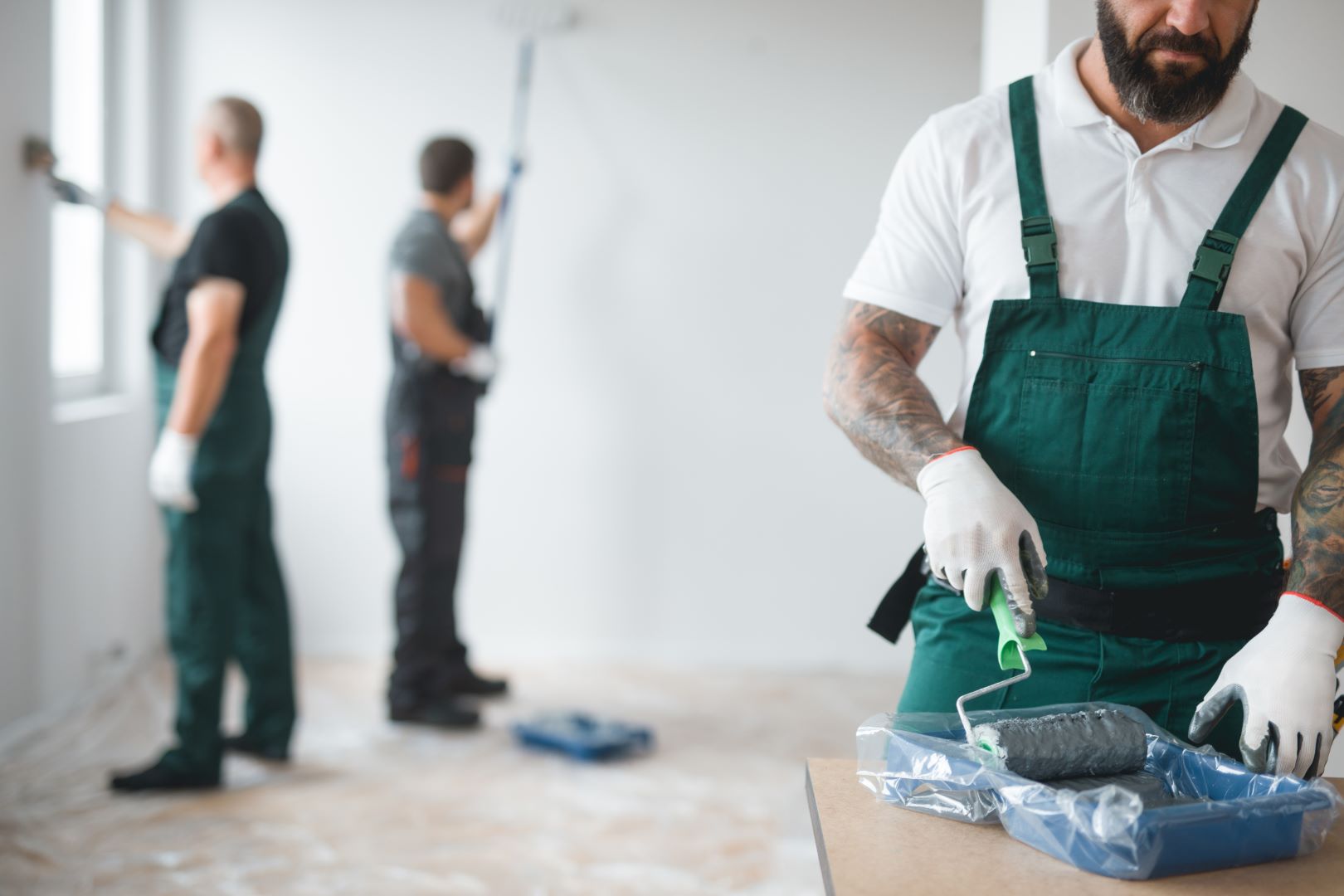 Three handymen painting a wall